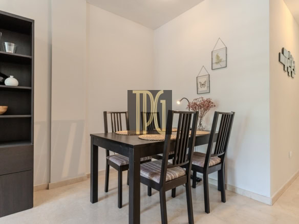 Dining room with a dark wooden table and four chairs, a tall black shelving unit on the left, and light walls.