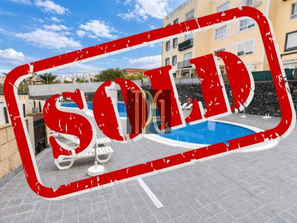Outdoor pool area of a residential complex with a large red SOLD stamp across the image.