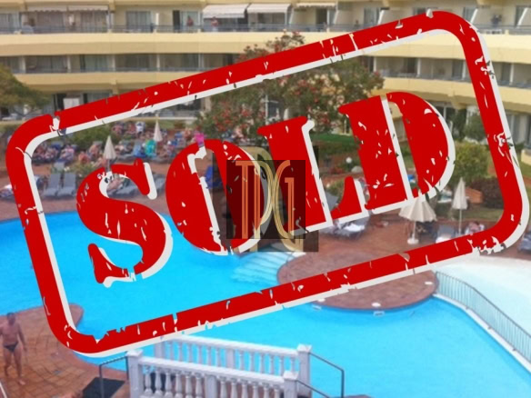 Overhead view of a hotel pool with a large red 'SOLD' stamp across it.