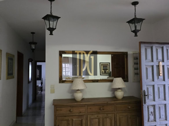 Interior foyer with a wooden sideboard, two ceramic lamps, and a large gold-framed mirror above the cabinet.