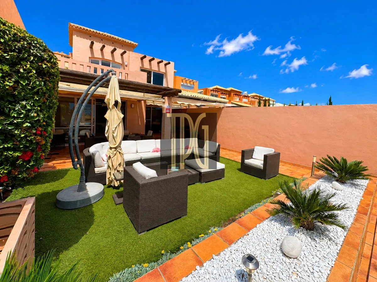 File 00001jpg Sunny rooftop terrace with black wicker furniture, white cushions, a closed umbrella, and a green artificial lawn.