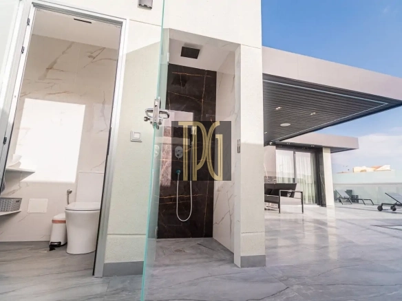 Modern rooftop terrace with a glass-enclosed outdoor shower, an adjacent bathroom, and sun loungers on a marble-tiled deck.