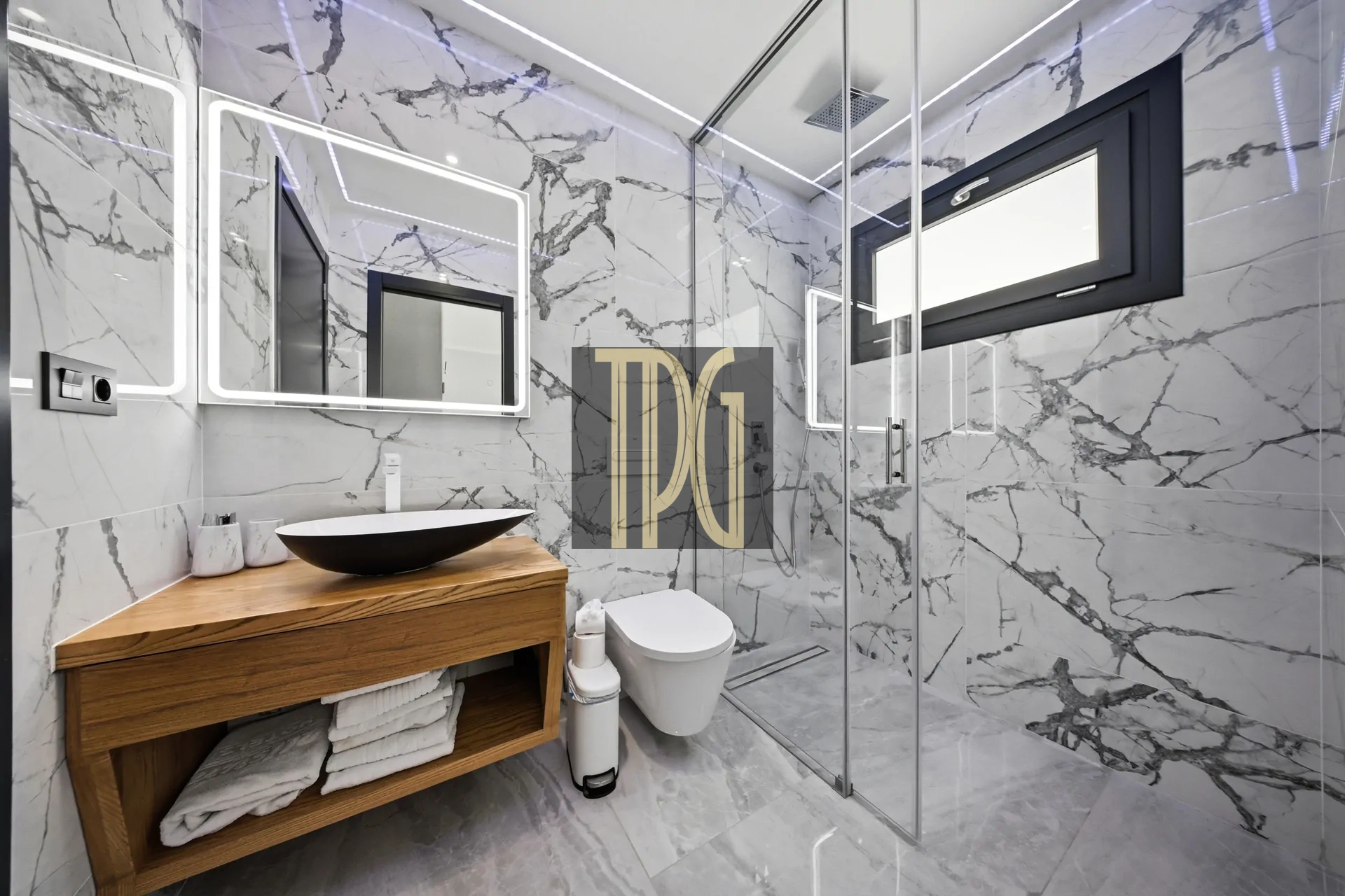 Modern marble bathroom with glass shower, wooden vanity, and backlit mirrors.