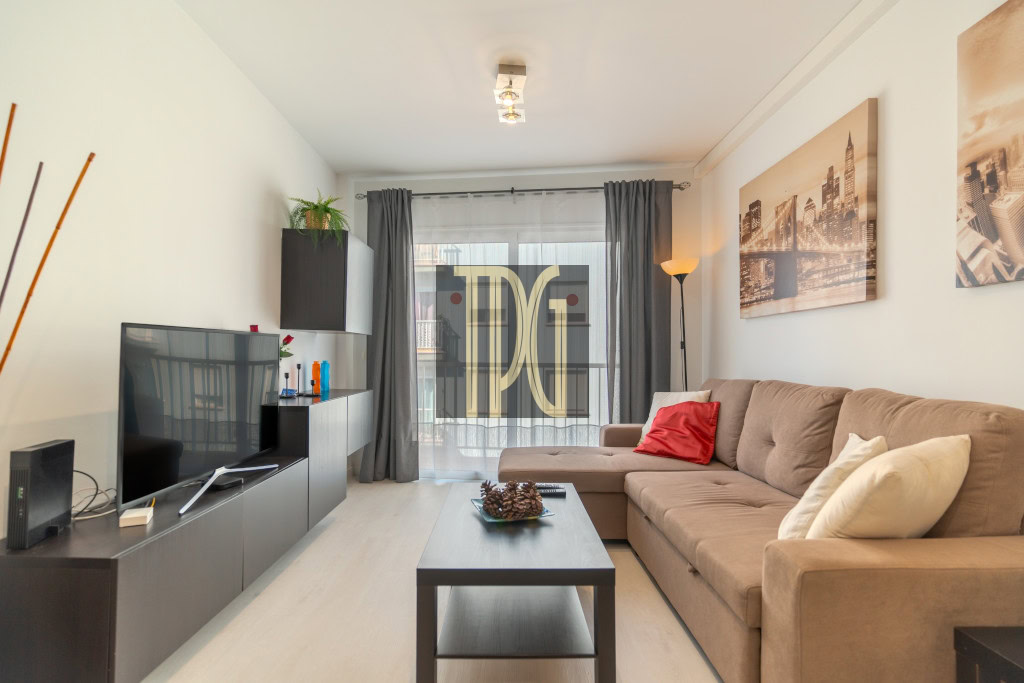 Cozy modern living room with a brown sectional sofa, coffee table, and flat-screen TV facing the seating area.
