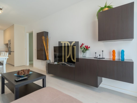 Modern living room with a dark wood wall unit, TV, and black coffee table; pinecone centerpiece and colorful vases on the sideboard.