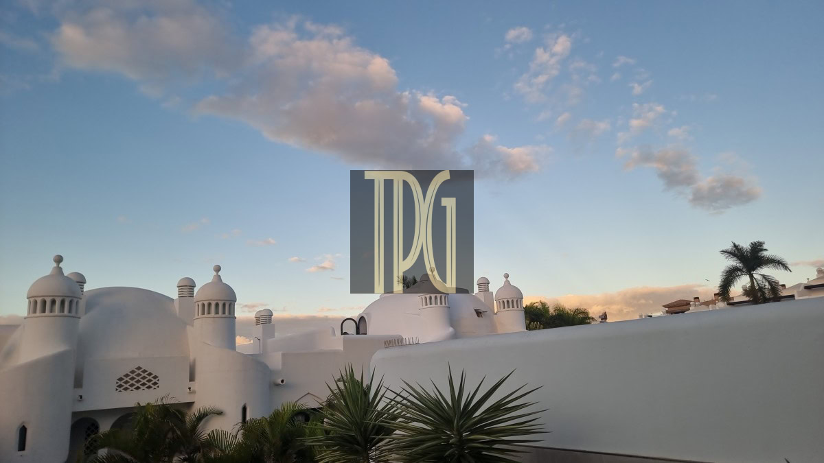 White domed buildings with palm plants against a blue sky; a TDG watermark sits centered on the image.