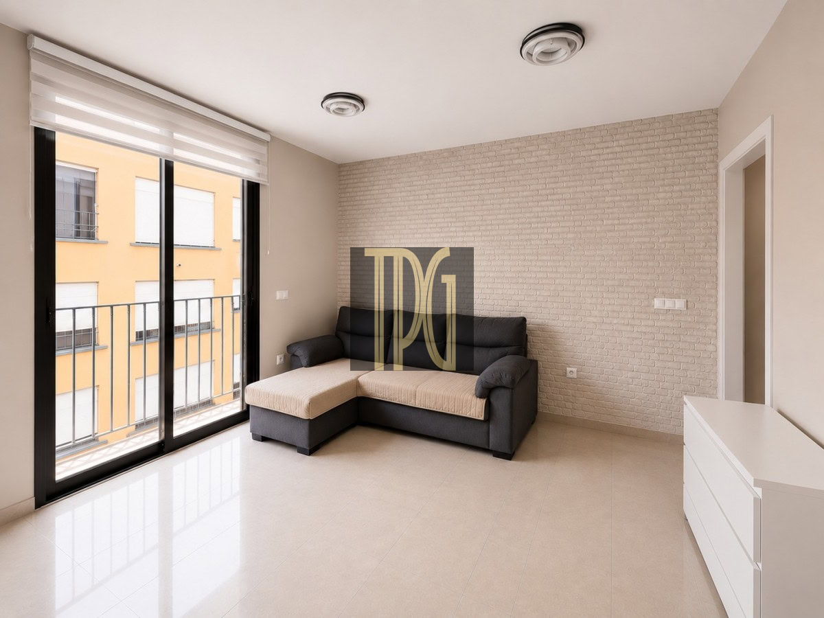 Unknown-12 Living room with a dark gray L-shaped sofa and beige cushions beside a glass balcony door, white brick accent wall behind it, and a white dresser to the right.
